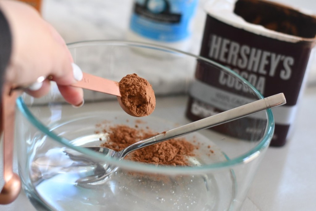 measuring cocoa powder into into bowl