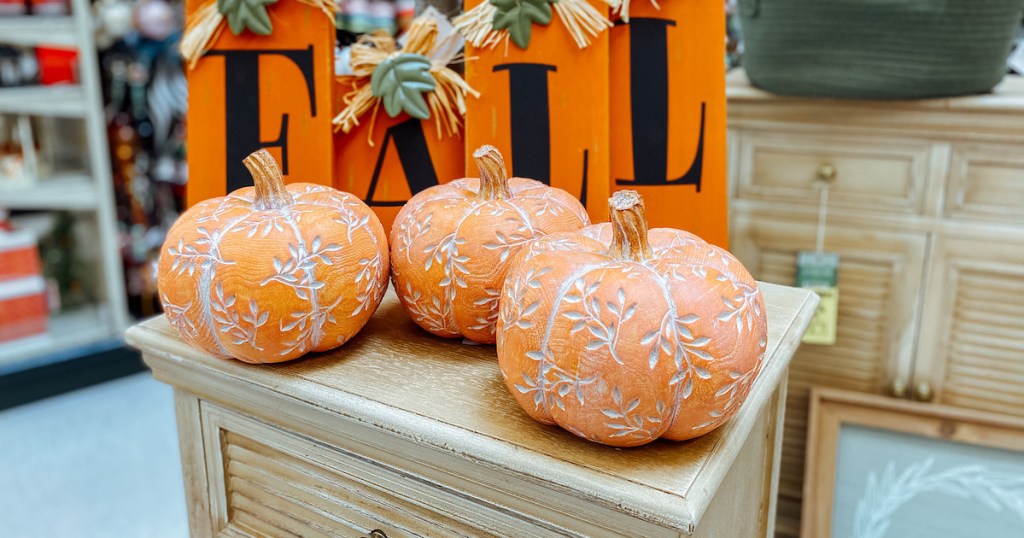 close up of three orange pumpkins with detailing on furniture in store