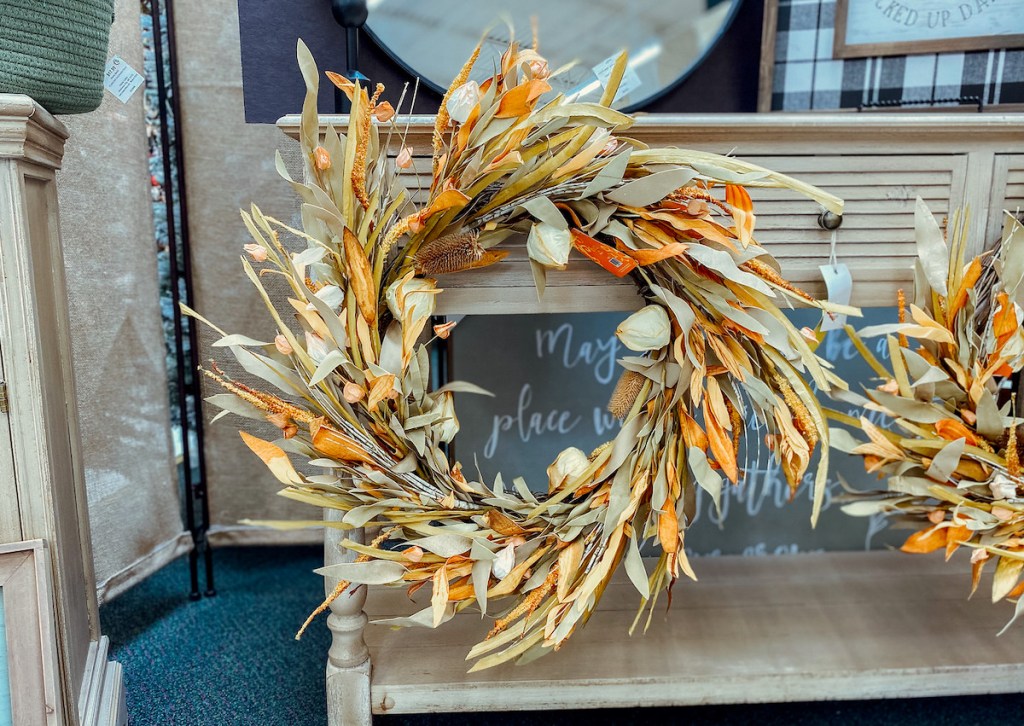 fall wreath hanging on dresser in store