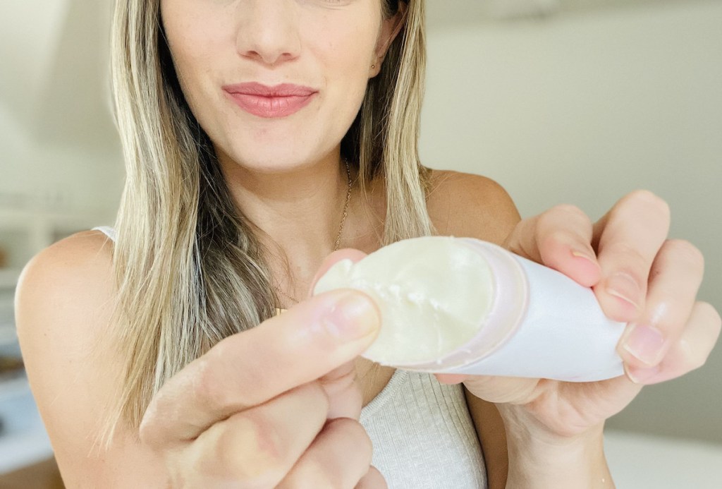 woman using fingertip to scrape top of deodorant stick