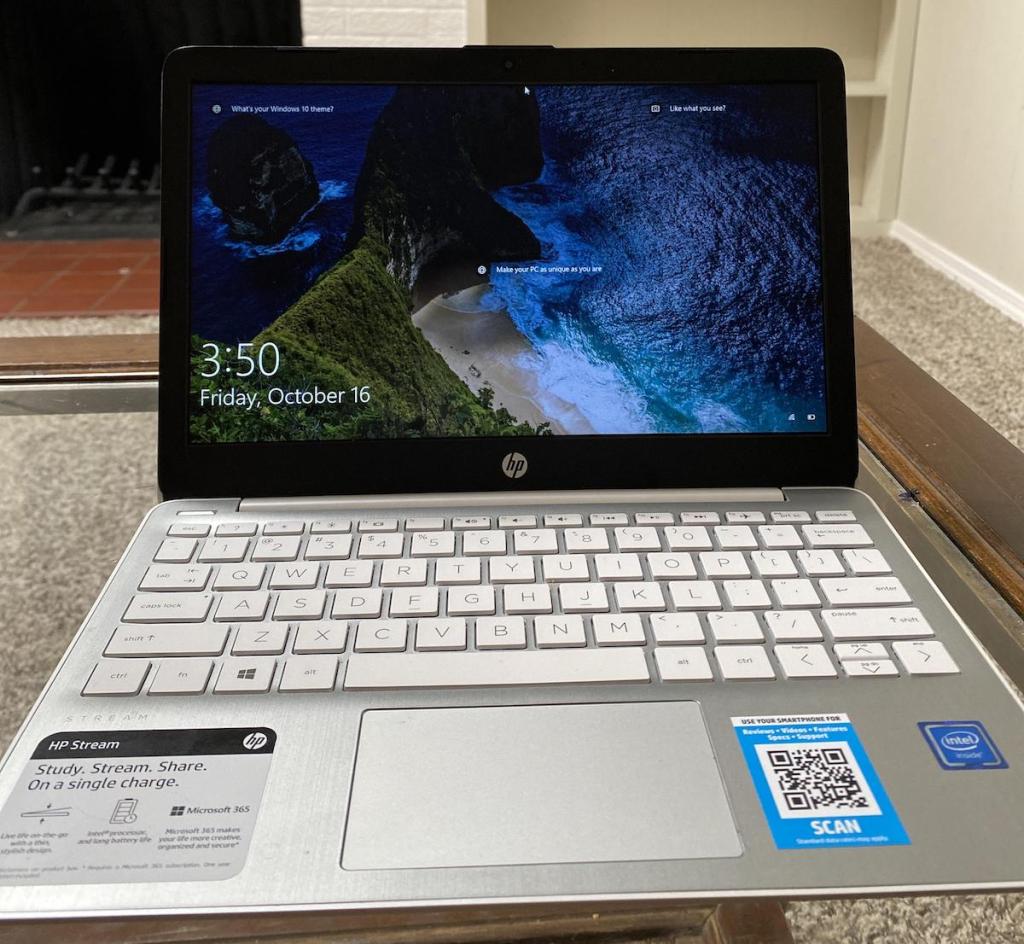 hp stream laptop with stickers sitting on table in living room