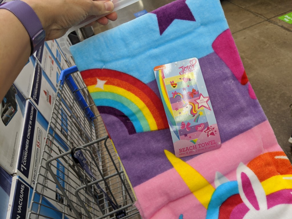 hand holding colorful towel over shopping cart