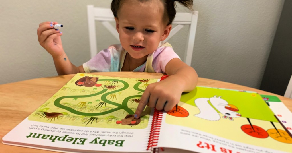 little girl drawing in highlights book