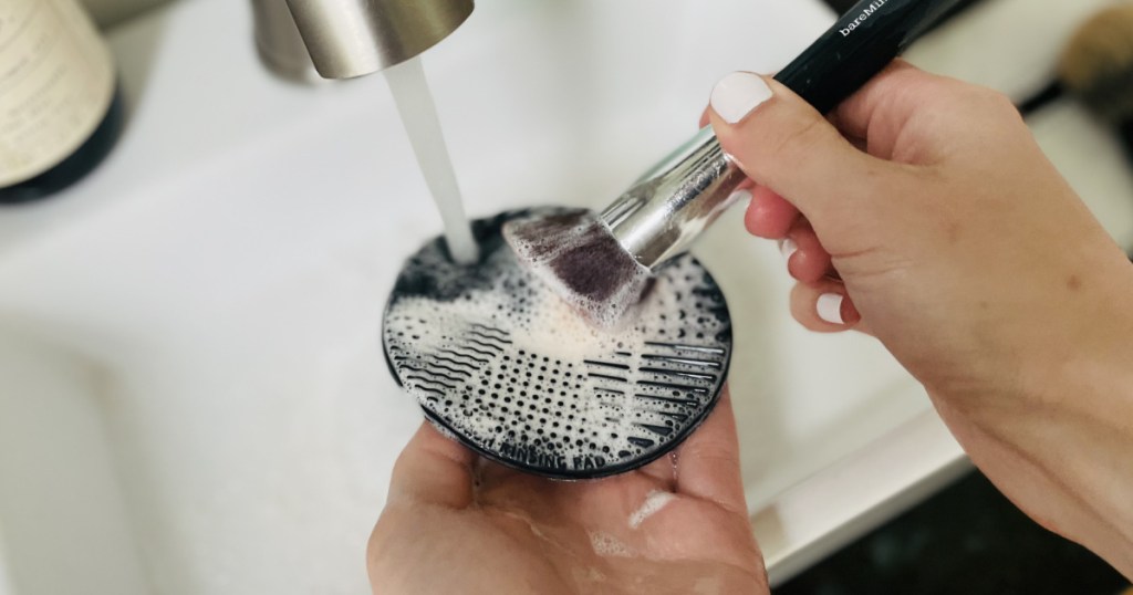 using silicone makeup brush cleaner at sink