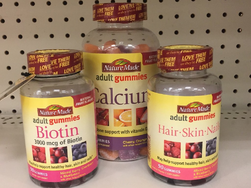 store shelf with 3 bottles of vitamins sitting on it