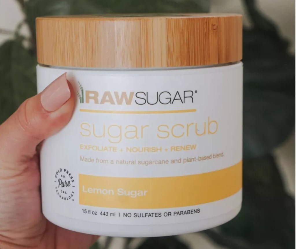 hand holding sugar scrub with bamboo lid