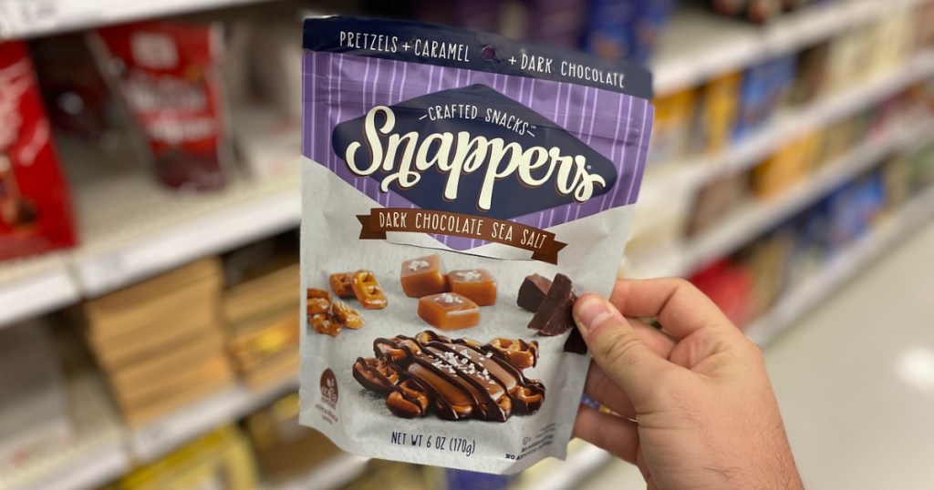 hand holding bag of chocolate by store shelves