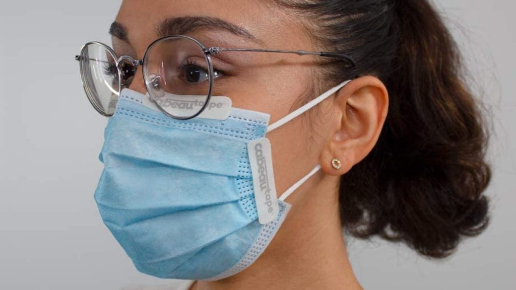 woman wearing blue mask with eyeglasses and tape