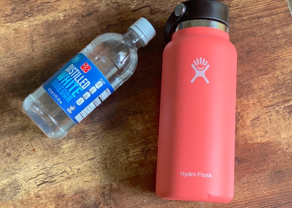 how to clean water bottles pink hydroflask water bottle next to bottle of white vinegar