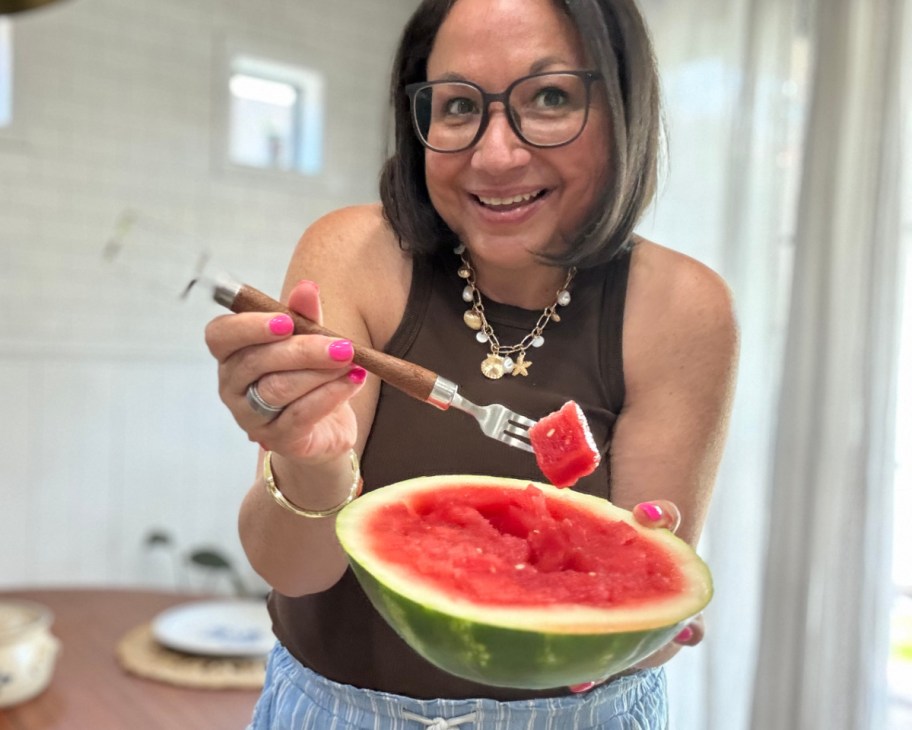 woman holding watermelon slicer and watermelon half