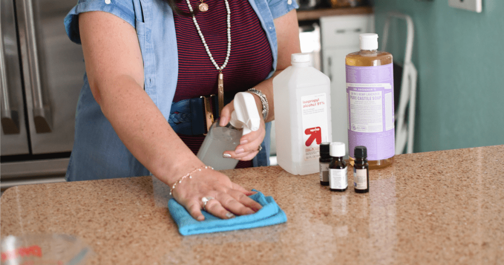 woman cleaning counters with granite spray