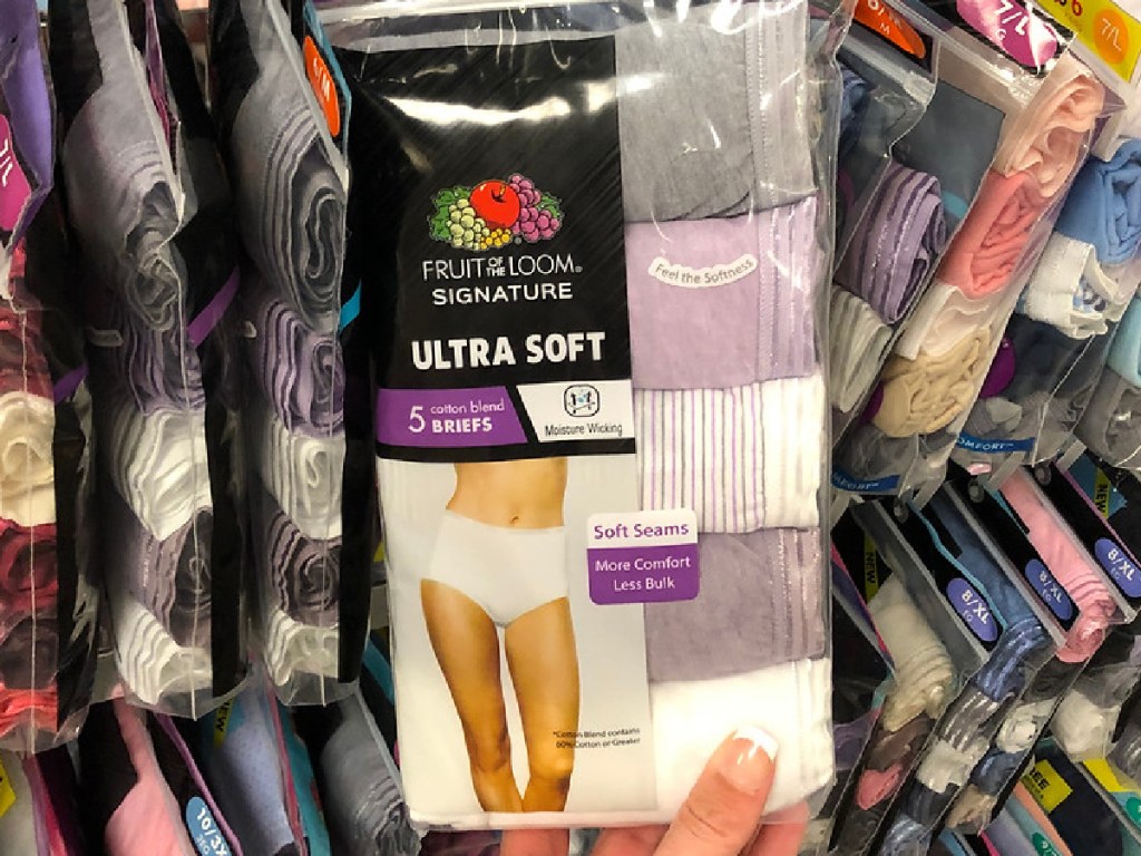 hand holding a package of women's underwear by store display