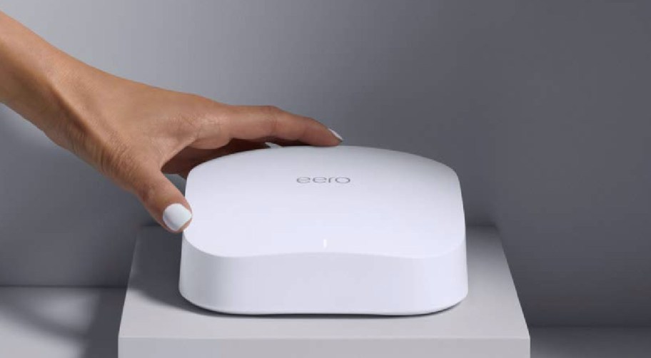 hand touching white WiFi router