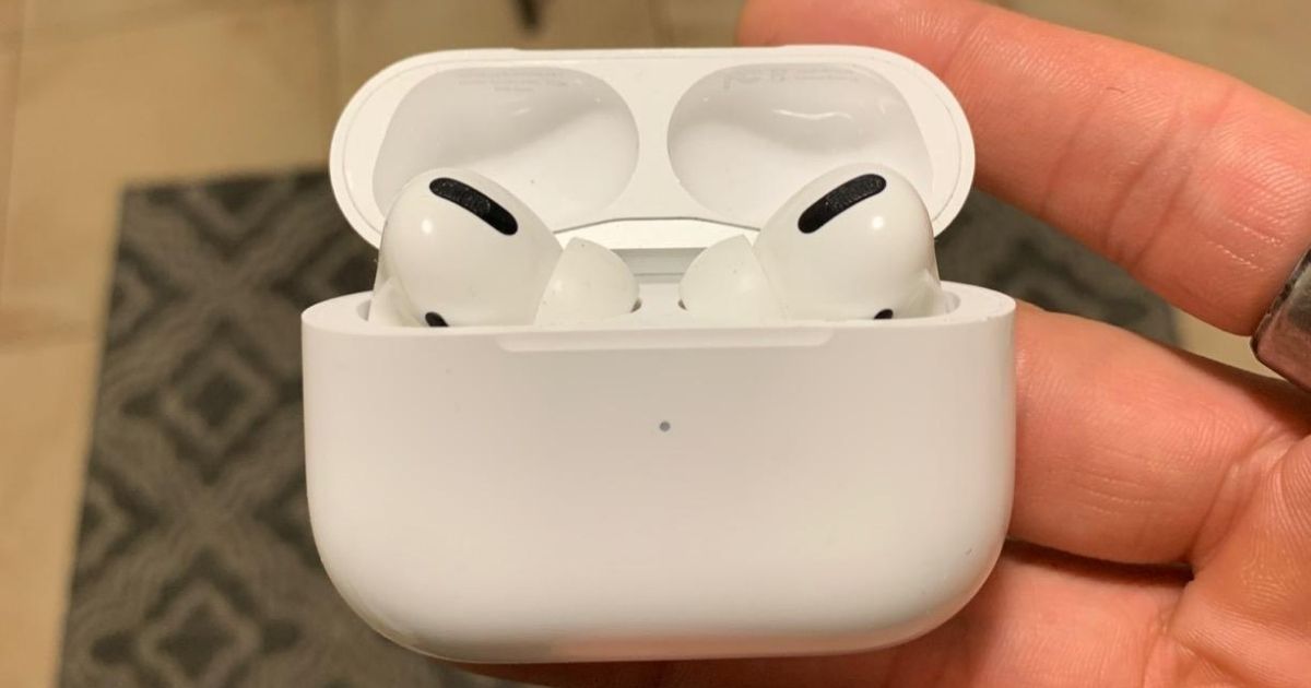 hand holding Apple AirPods Pro earbuds in charging case
