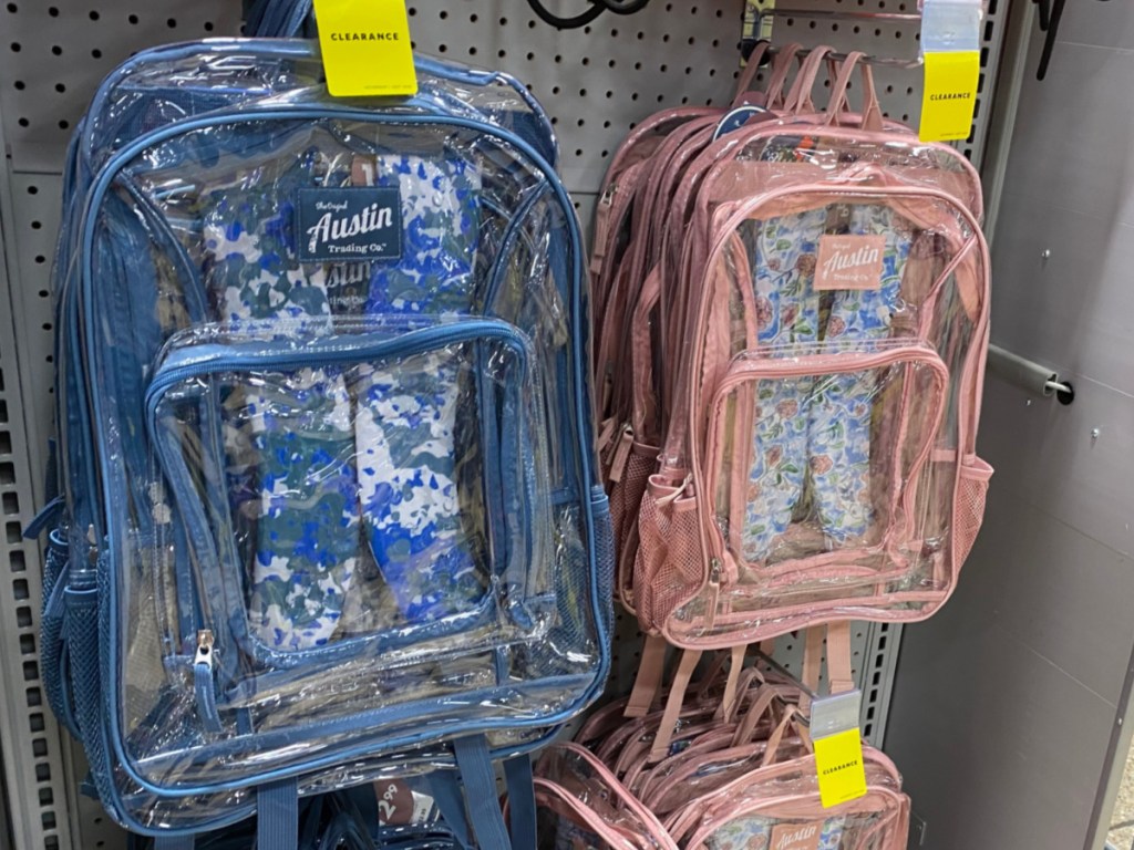 blue clear backpack and pink clear backpack hanging in store