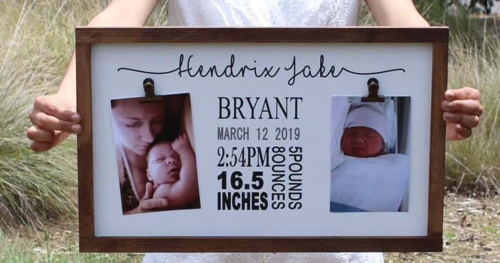 woman holding a sign with baby birth information and pictures