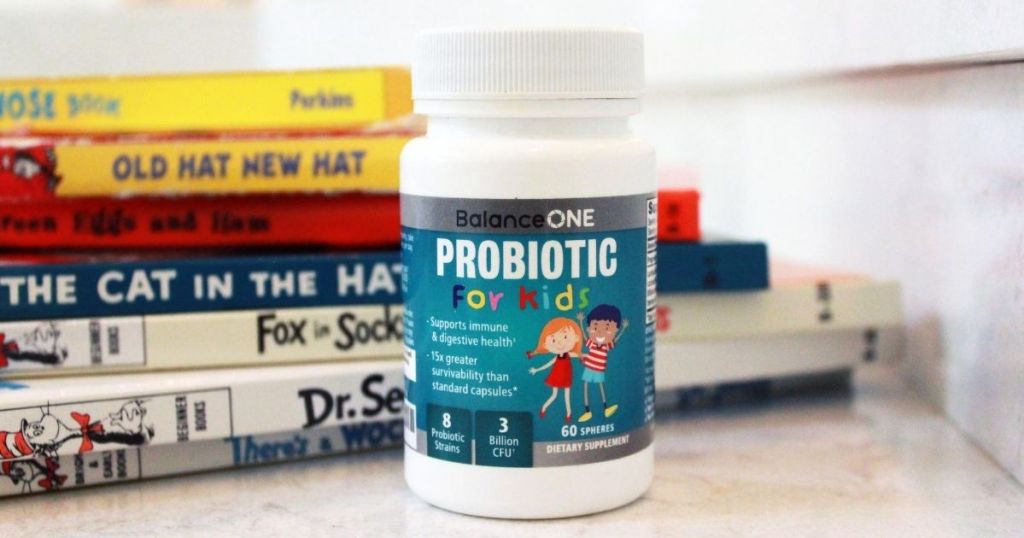 bottle of Balance ONE Probiotics for Kids by stack of books