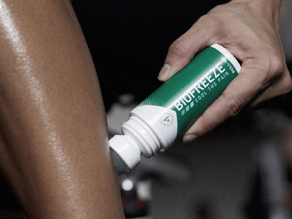 Hand holding Biofreeze Pain Relief roll-on stick