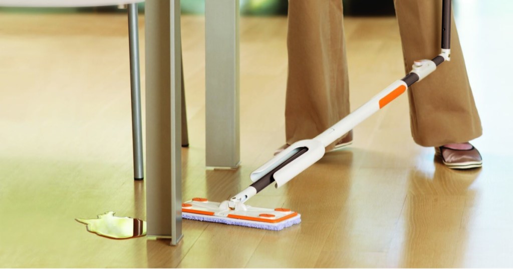 person using mop to clean spill on floor