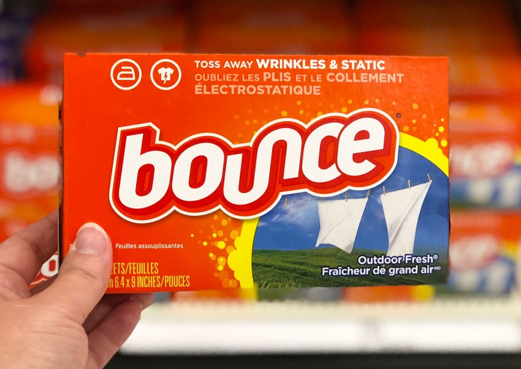 person holding up an orange box of outdoor fresh scented bounce dryer sheets