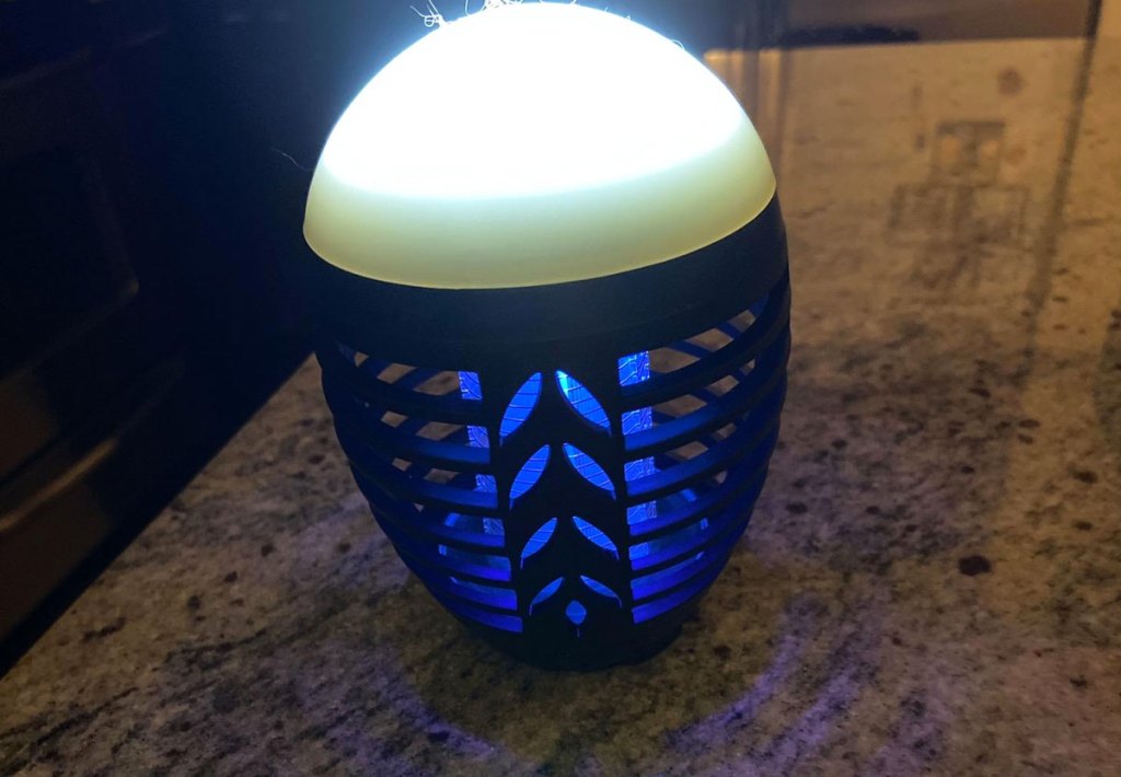 black plastic bug zapper with blue uv light and white led light on top