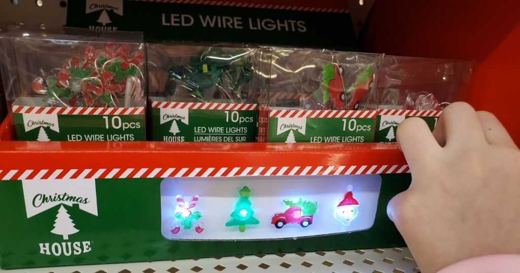 hand placed on Christmas House LED string lights on store shelf