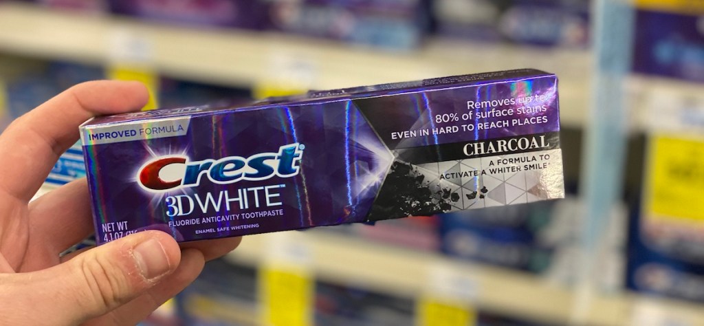 hand holding box of Crest 3D White Charcoal toothpaste