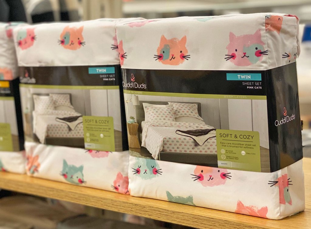two sets of twin size sheet sets with cat print on a kohl's display shelf