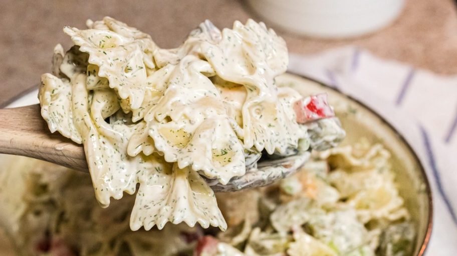 dill pickle pasta salad on wooden spoon