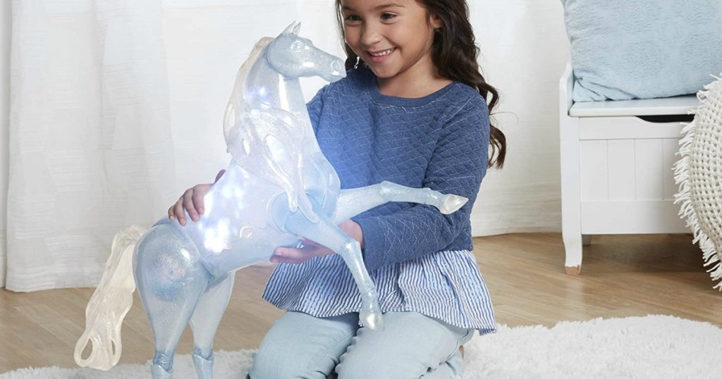 girl playing with a disney frozen horse toy