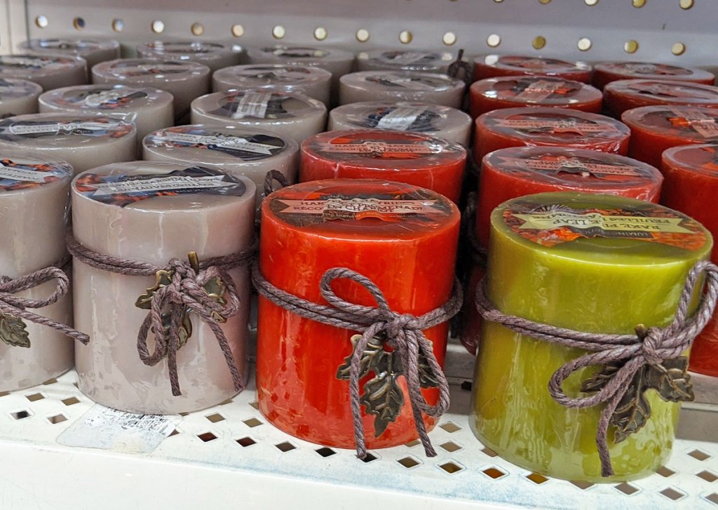 silver, red, and green pillar candles with rope bows and metallic leaves on each one