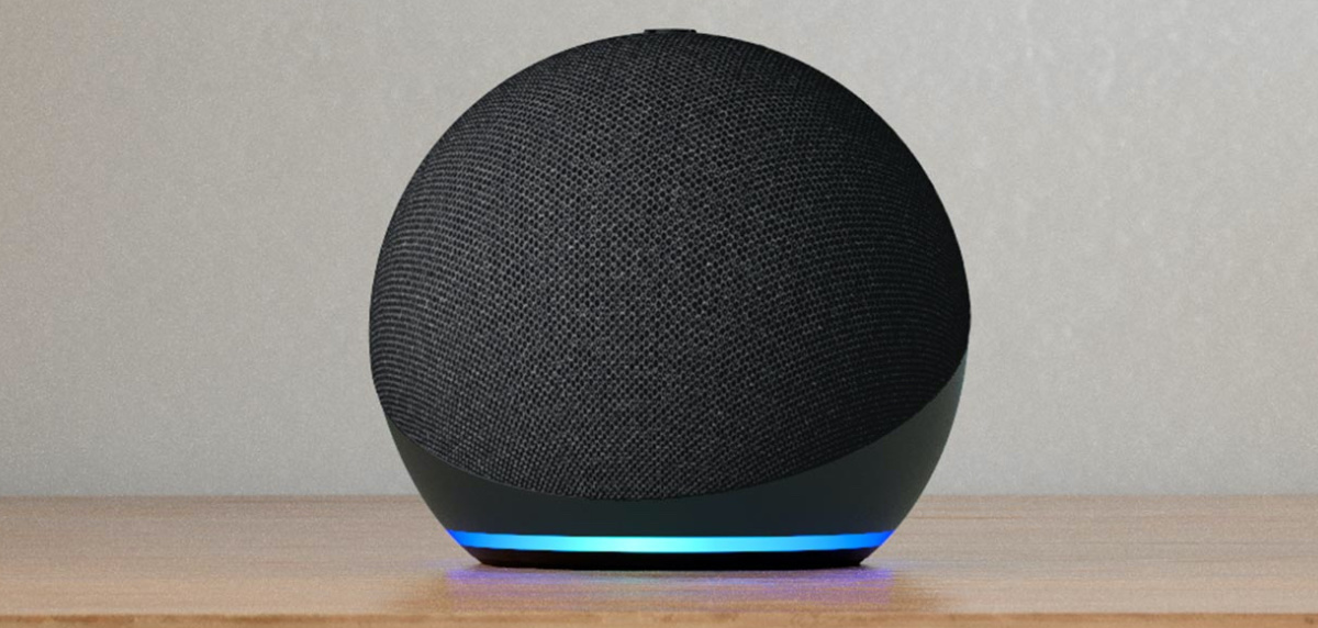 black smart speaker with blue light on wood table
