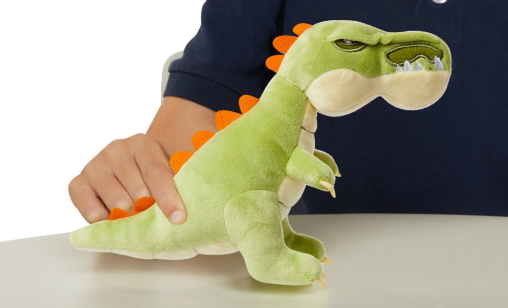 child playing with green dinosaur plush
