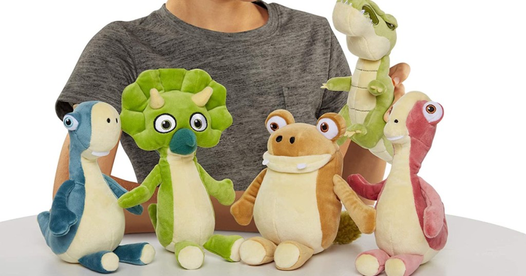 child and five dinosaur plush toys on table