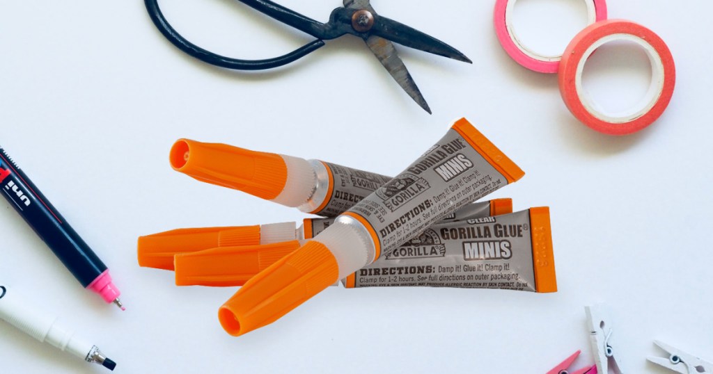 four tubes of super glue, scissors, tape, and more crafting supplies