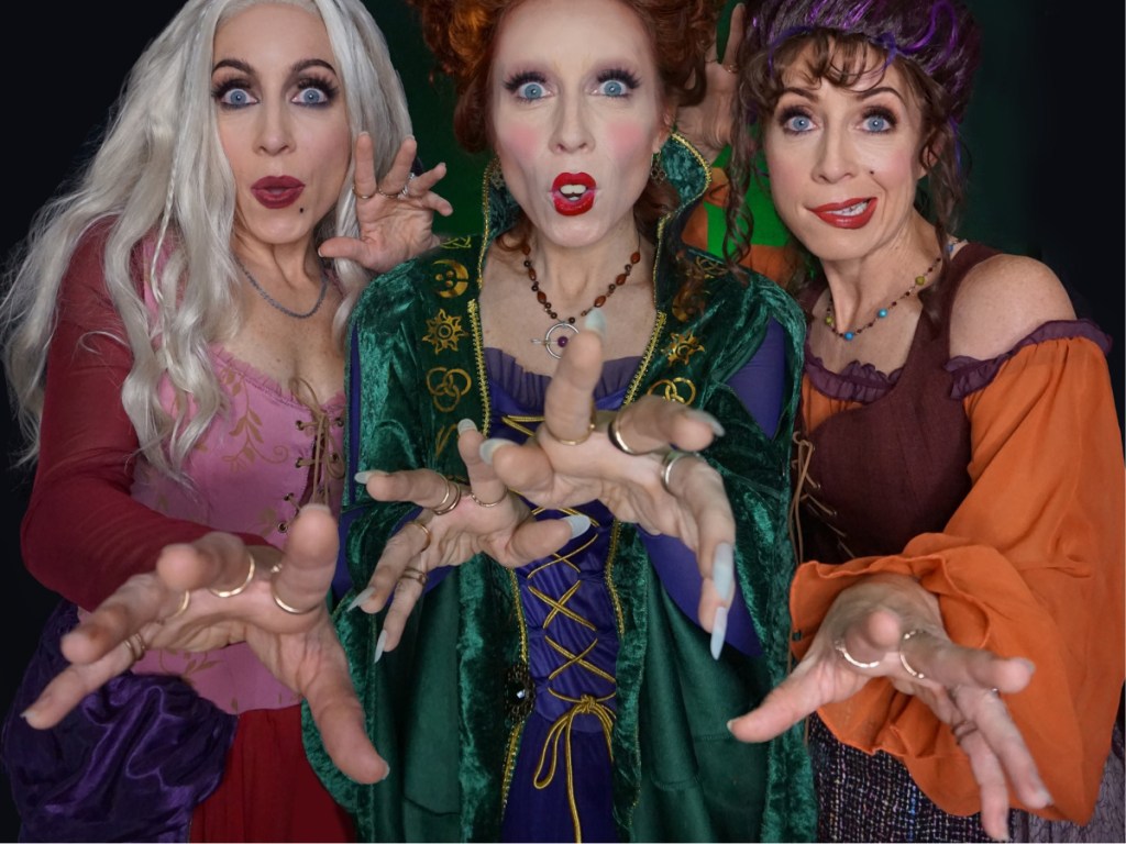 three women in witch costumes