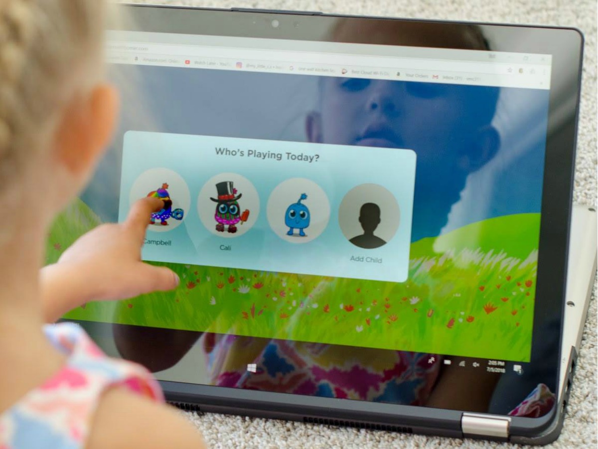 Young girl playing an educational game on a 2-in-1 laptop