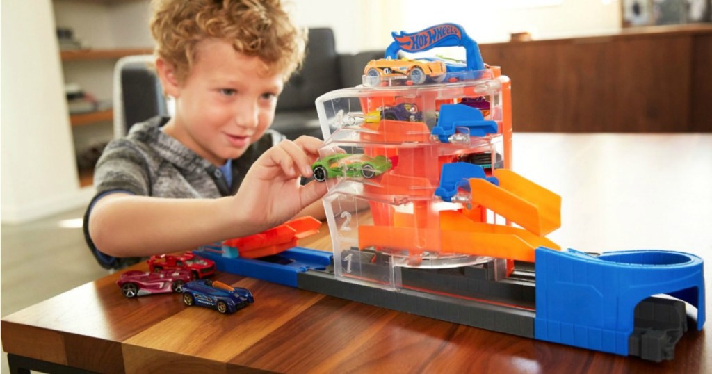 young boy playing with hot wheels track