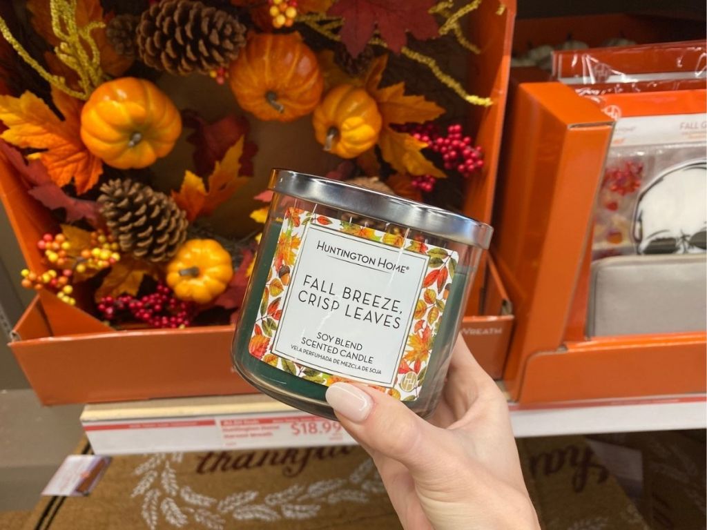 hand holding Huntington Home Fall Breeze Crisp Leaves Candle in store