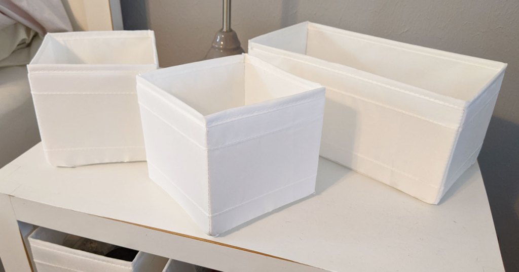 three white fabric storage boxes on white table