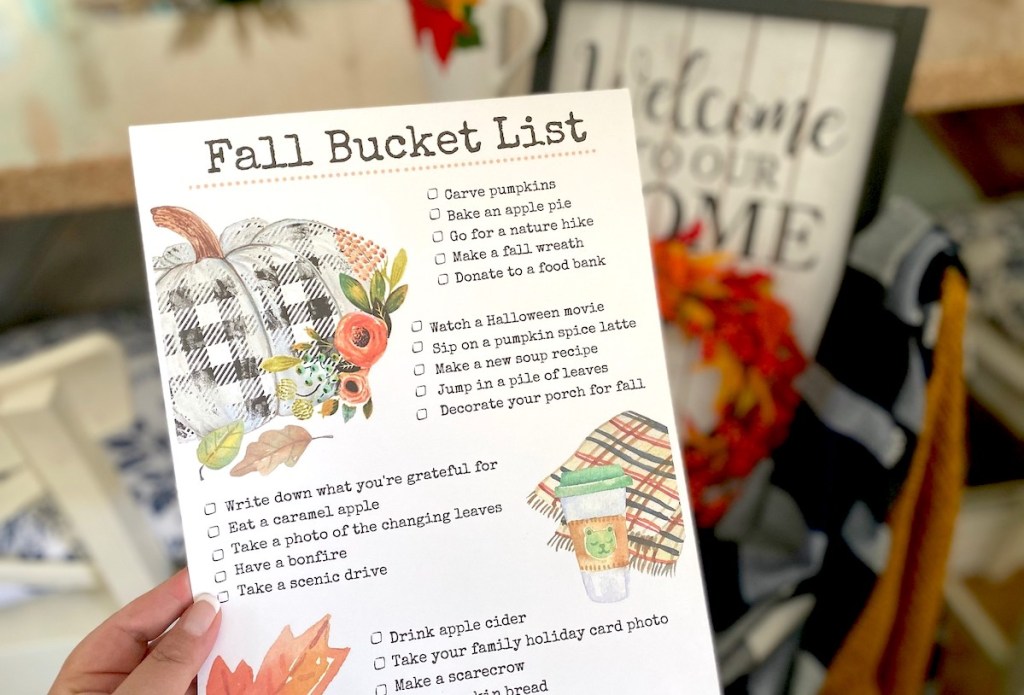 hand holding a fall bucket list in front of home decor