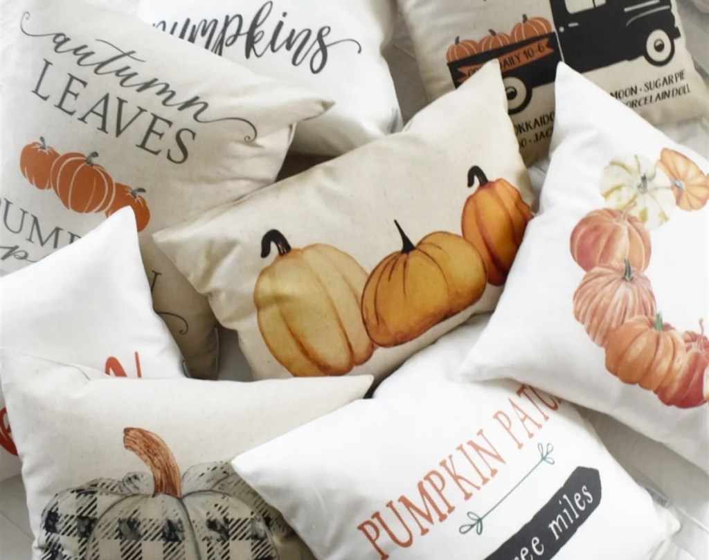 throw pillows with fall and pumpkin themed pillow covers on them