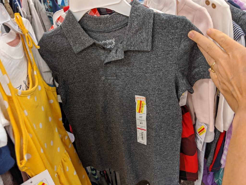 hand holding toddler boys gray polo shirt hanging in store