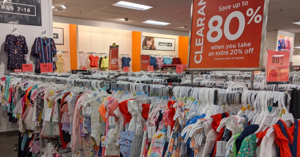 kids clothes hanging in store and clearance sign