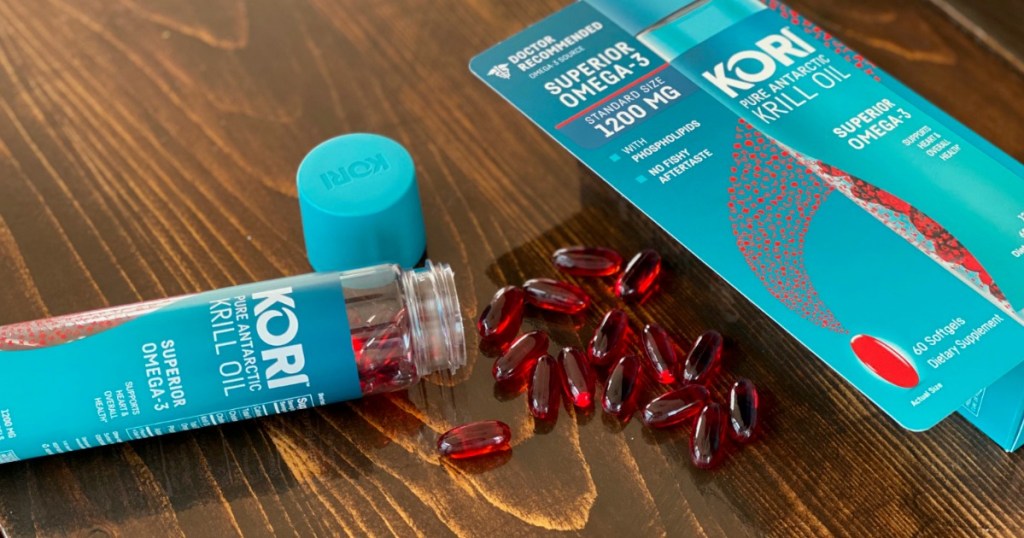 Kori Krill Oil bottle open on wooden table with red capsules