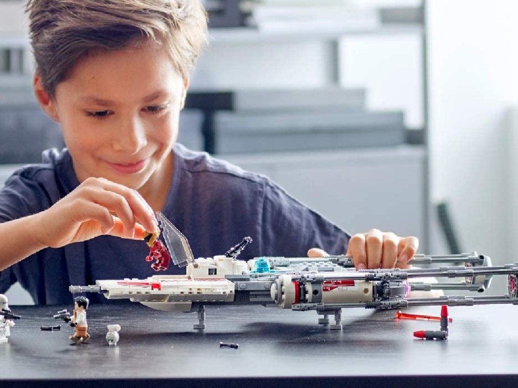 boy sitting down playing with a Star Wars Y-Wing Resistance Fighter Set