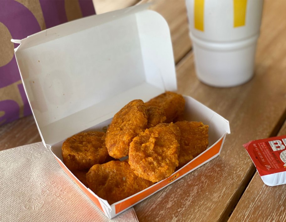 McDonald's spicy chicken nuggets on table near drink and dipping sauce