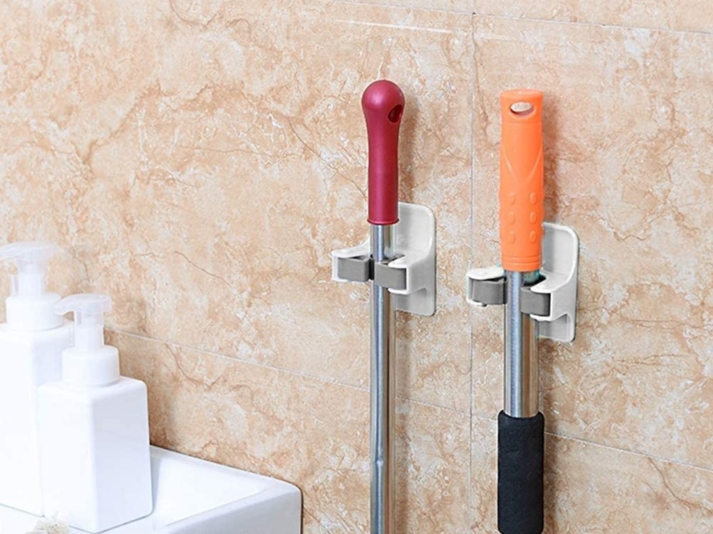 adhesive broom holders on bathroom wall