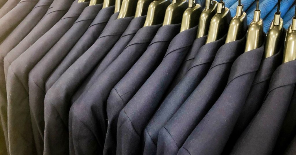 various shades of men's suits on gold hangers