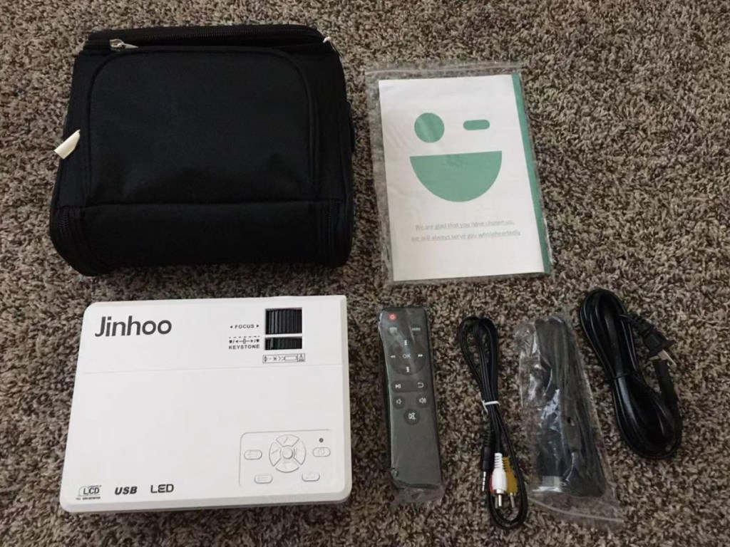 mini projector sitting next to wires and carrying bag
